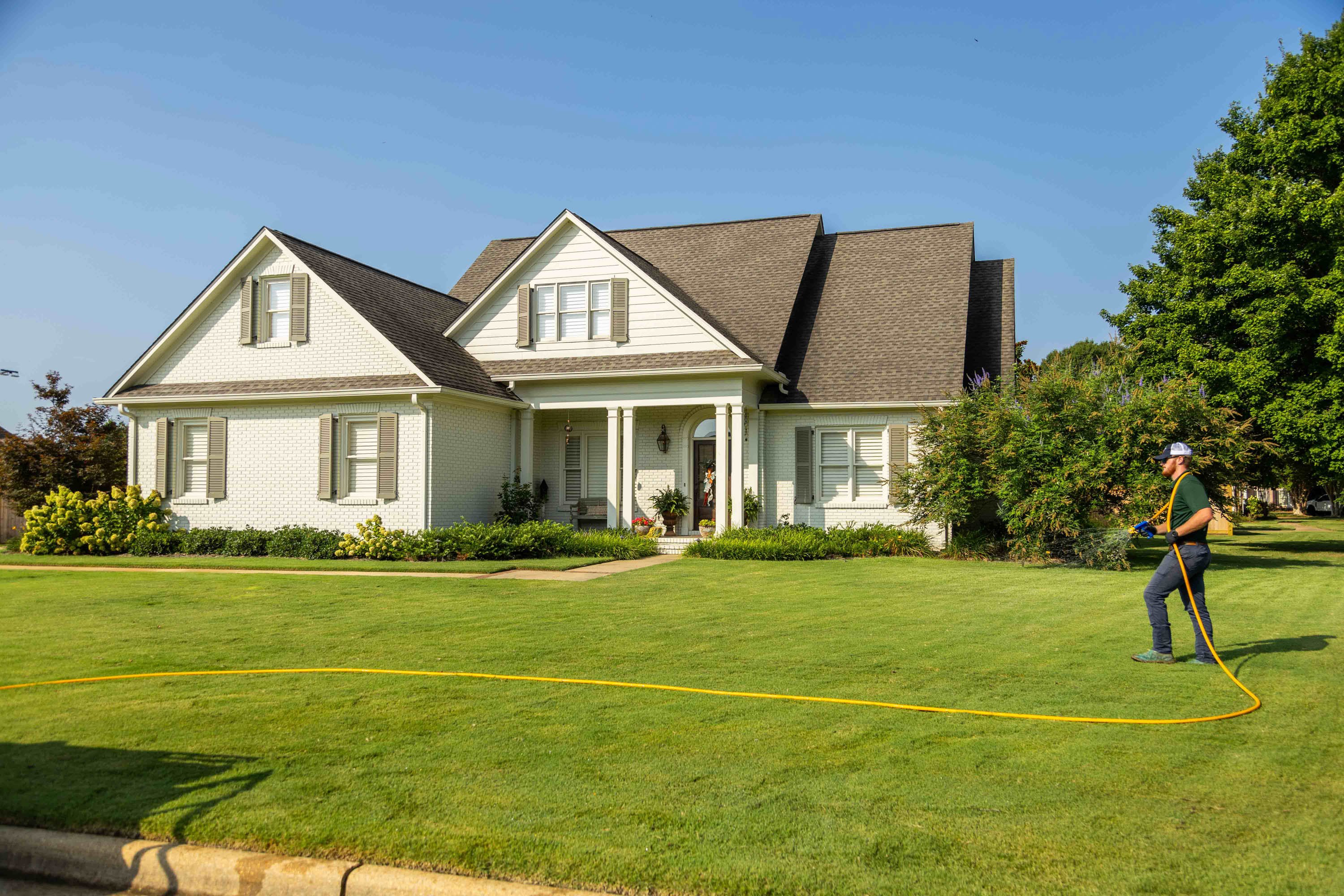 lawn care technician spraying a lawn