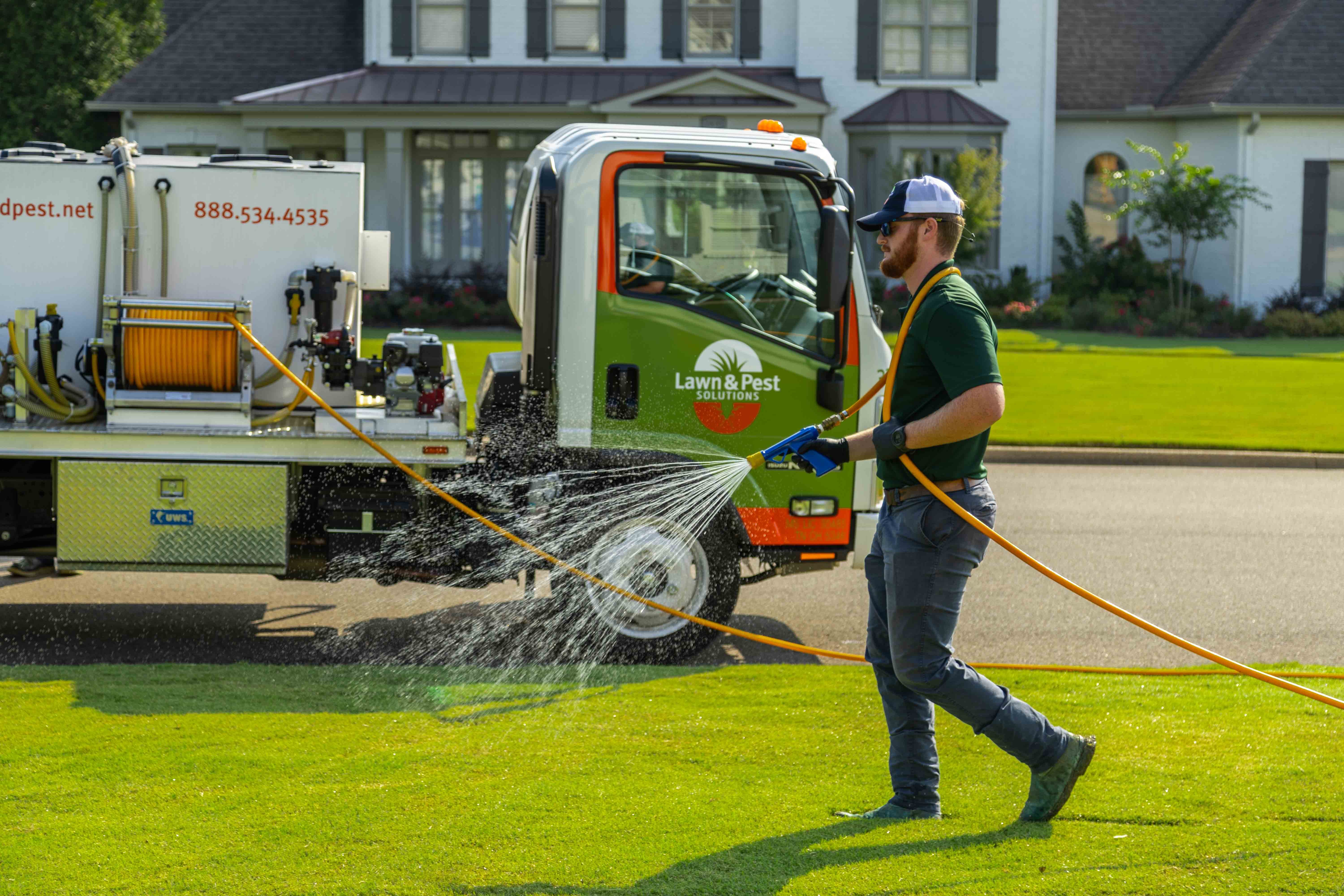 technician crew spray hose weed control lawn care grass green treatment truck