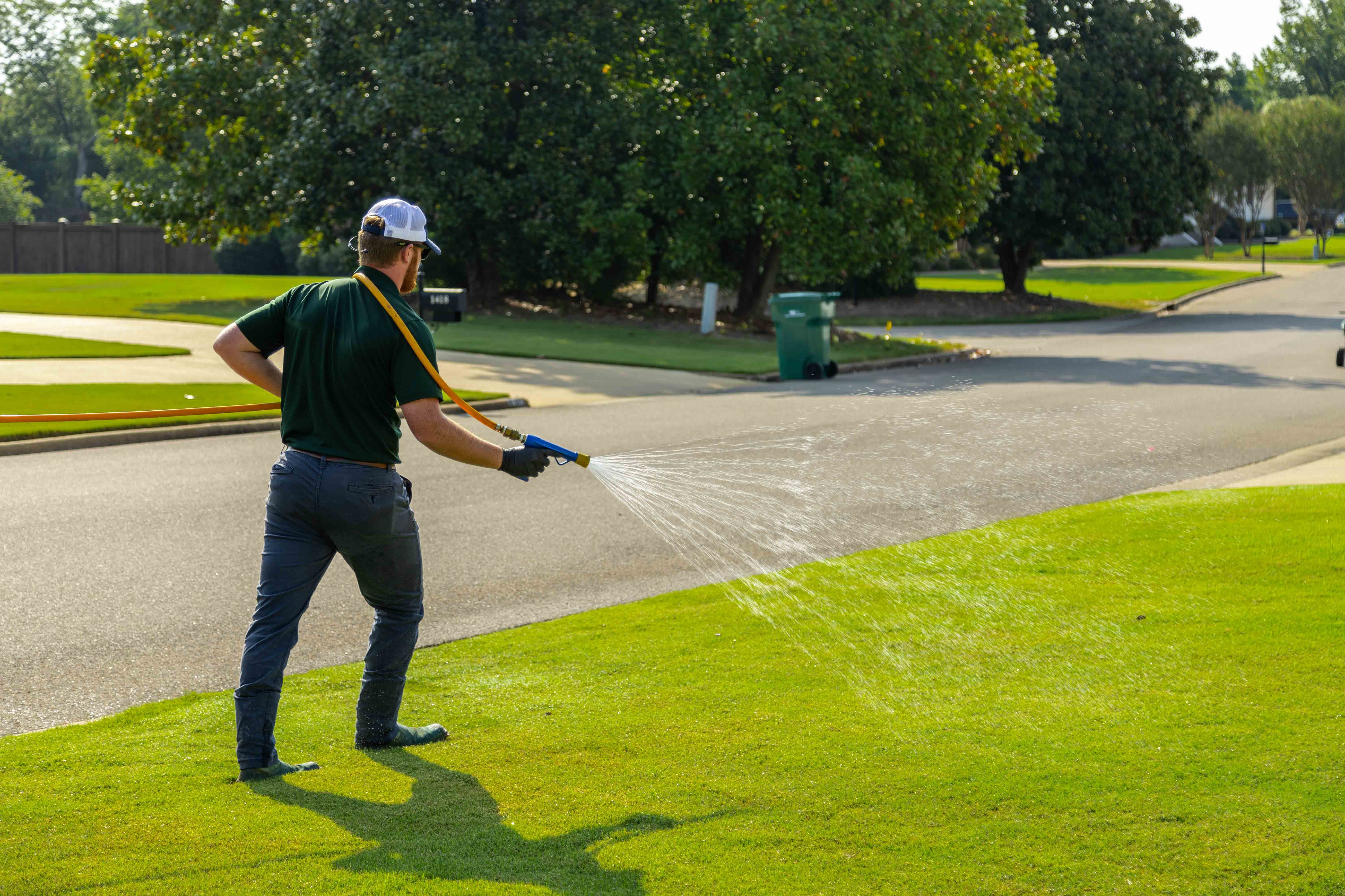 lawn care technician spraying a lawn for selective weed control in memphis