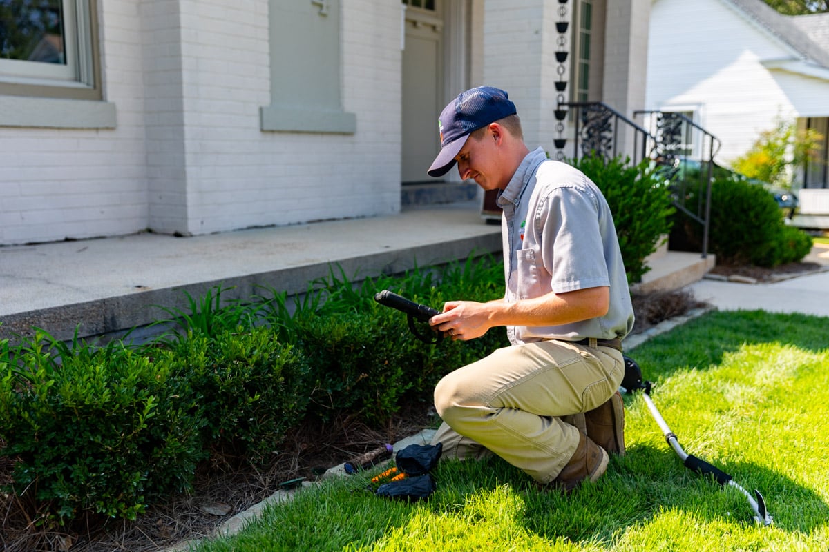 pest control technician drilling installing bait stations 10