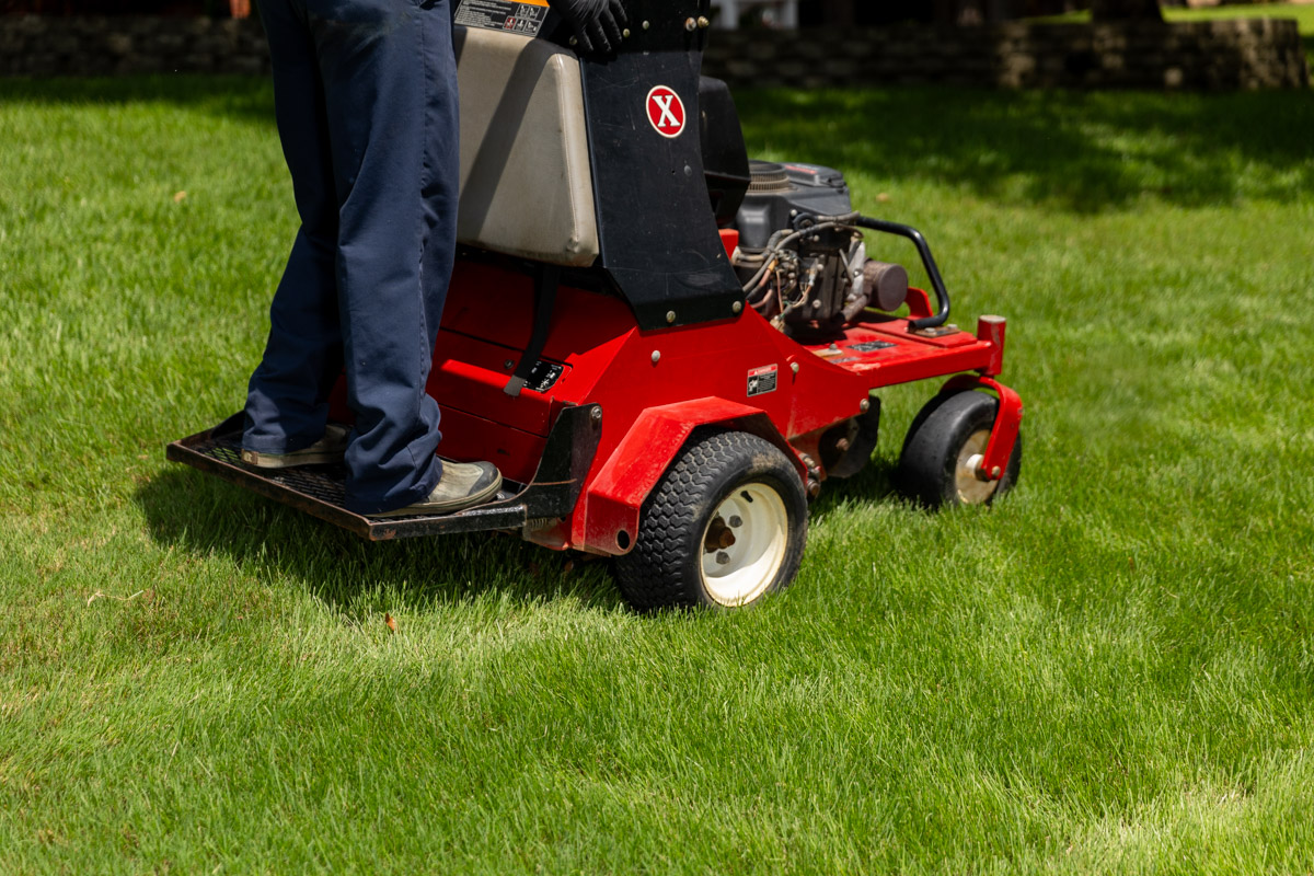 lawn care technician and aerator in lawn 3