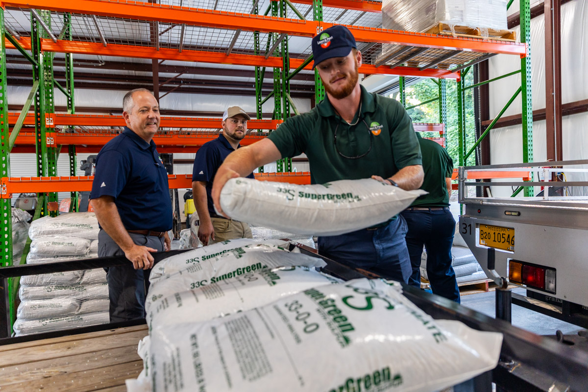 team members loading trailer with fertilizer shop garage 5